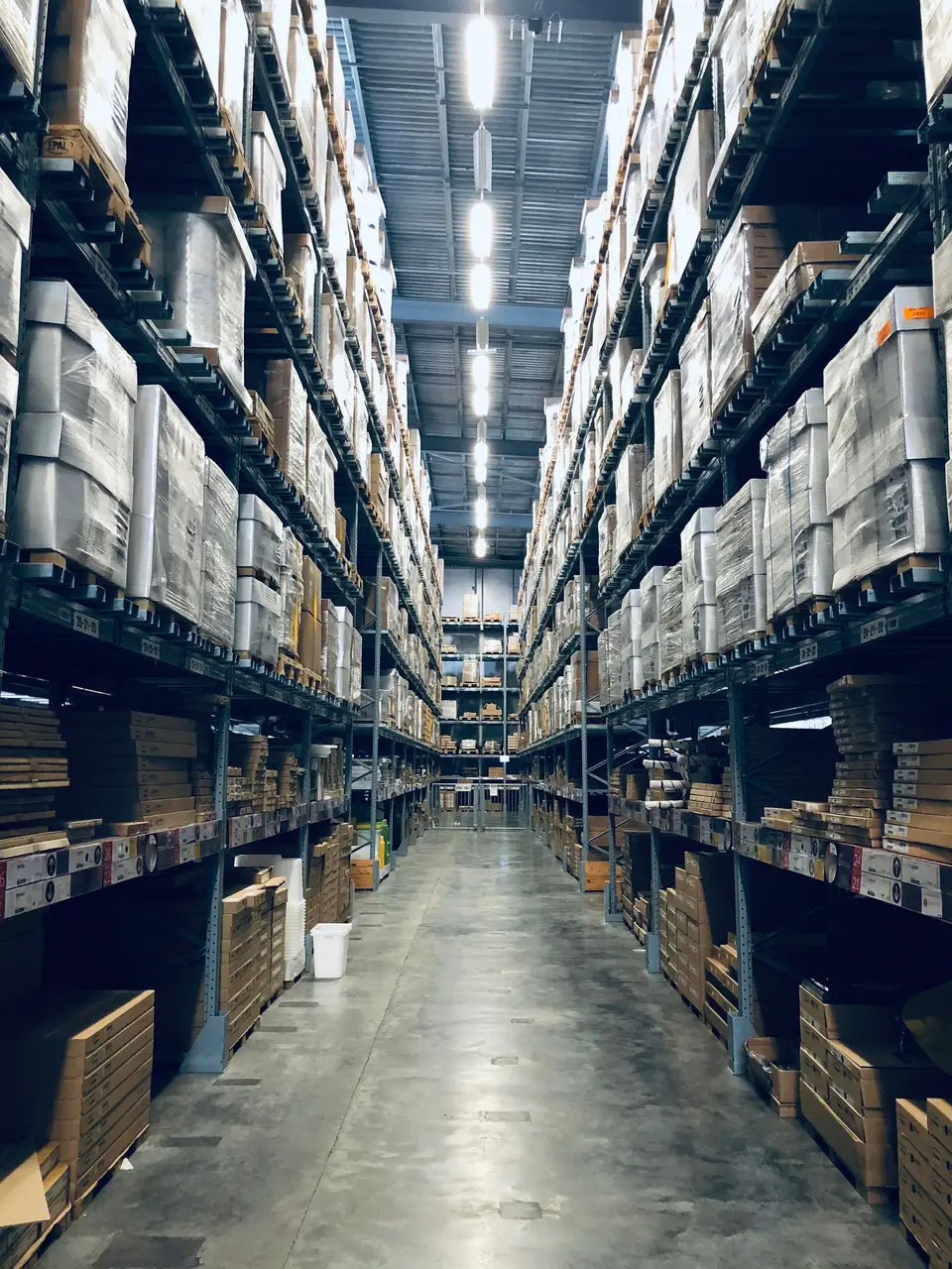 Warehouse aisle with tall shelves stocked with boxes